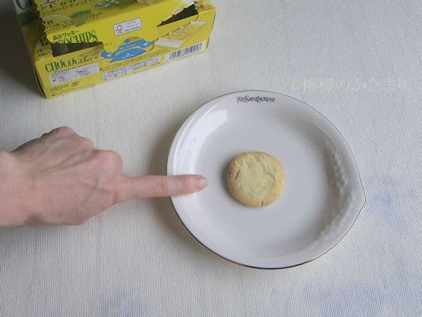 人差し指とレモンホワイトチョコチップクッキー一個で大きさを比較している